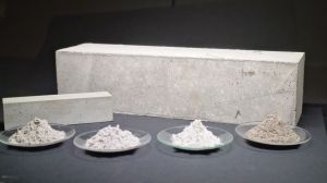 Van links naar rechts: portlandcement, gemalen gegranuleerde hoogovenslak, kalksteenmeel, poederkoolvliegas (op de achtergrond een betonprisma)